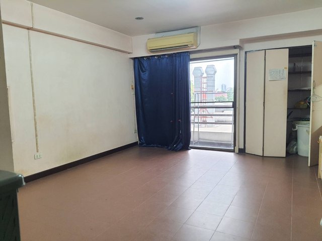 Bedroom of the Royal Park Condominium unit with air conditioner and balcony door
